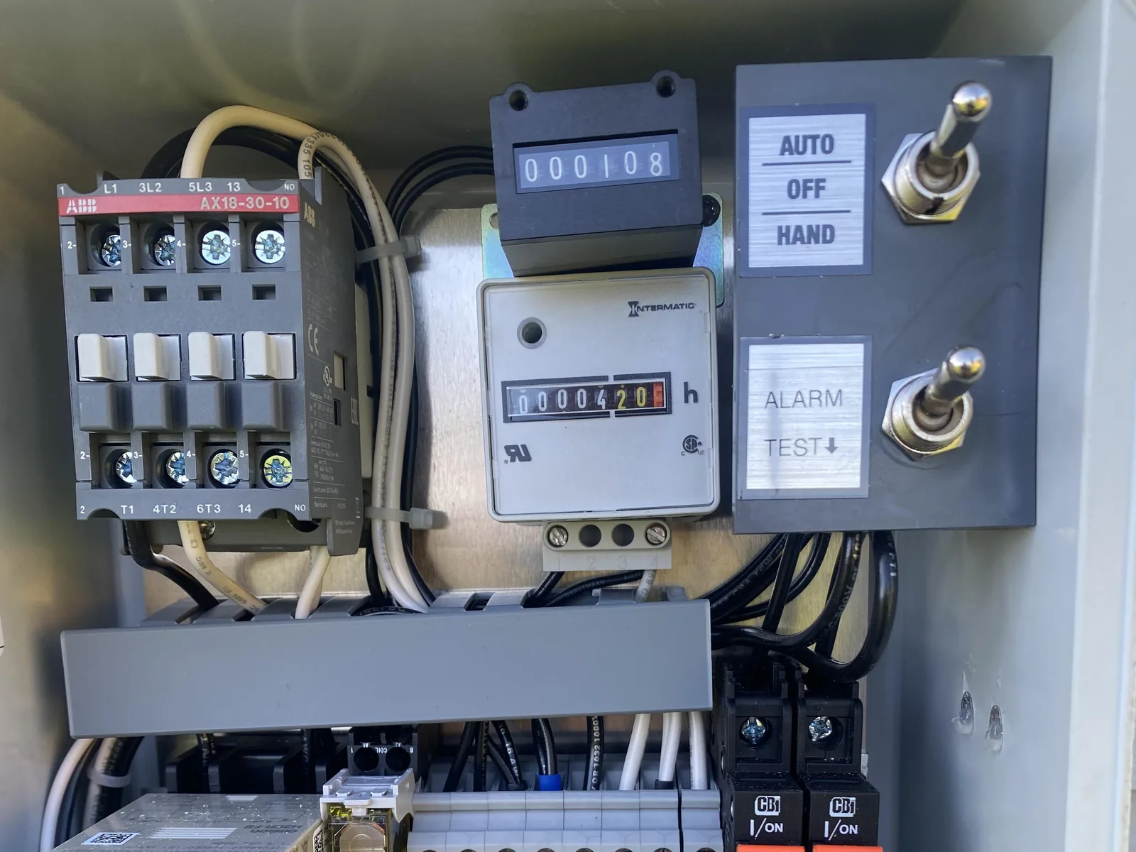 Open septic pump control panel with the contactor, pump run counters, hand off auto switch and breakers, lift station pumps