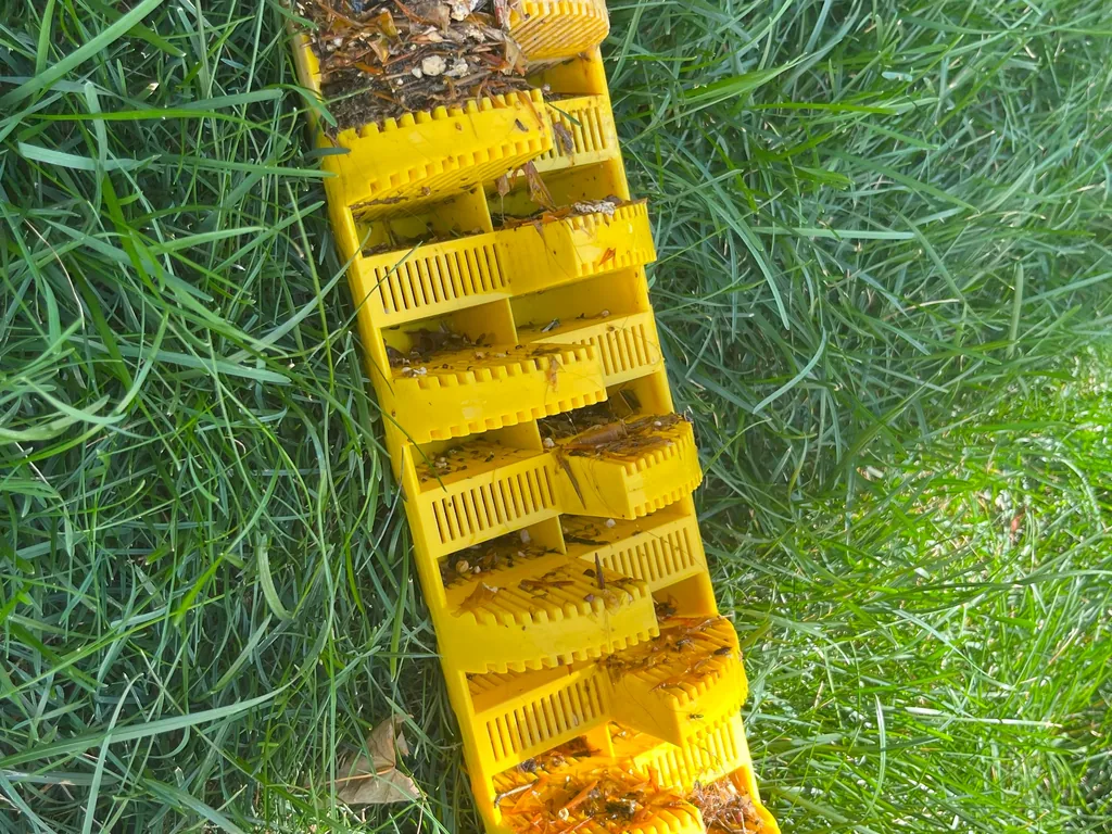 Clogged yellow effluent filter cartridge laid on the grass, septic tank filter cleaning