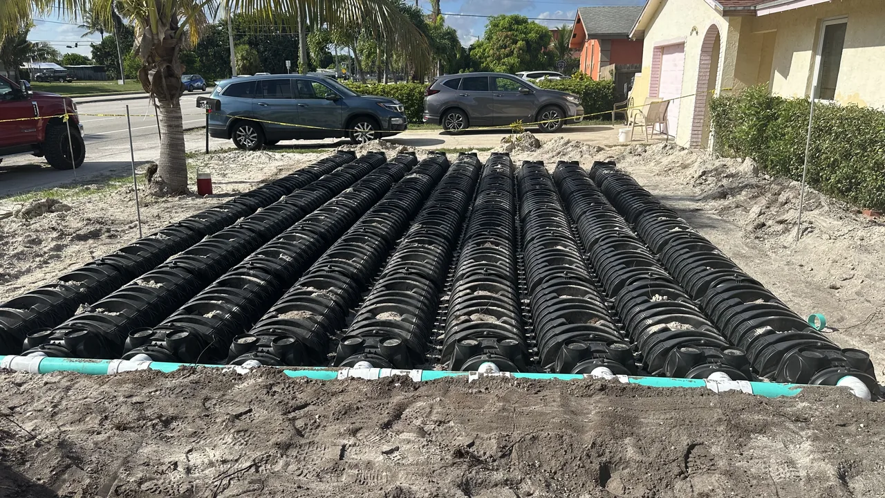 Septic drain field chambers laid in rows across a sandy front yard, septic system installation